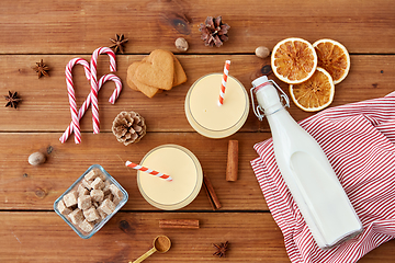 Image showing glasses of eggnog, ingredients and spices on wood