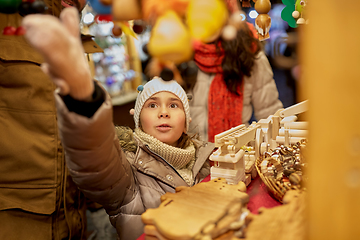 Image showing happy family buying souvenirs at christmas market