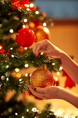 Image showing hands decorating christmas tree with ball