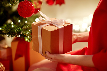 Image showing close up of woman with gift box at christmas tree