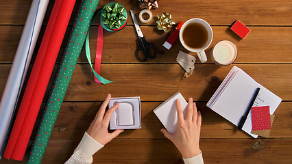 Image showing hands packing earphones for christmas gift