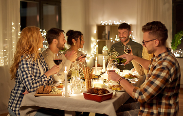 Image showing happy friends drinking red wine at christmas party