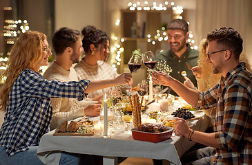 Image showing happy friends drinking red wine at christmas party