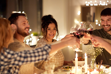 Image showing happy friends drinking red wine at christmas party