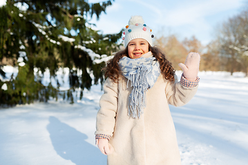 Image showing happy little girl waving hand outdoors in winter