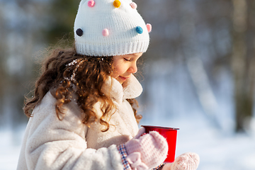 Image showing little girl with cup of hot tea in winter park