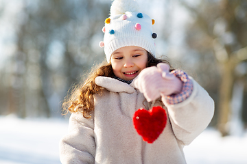 Image showing happy little girl with heart outdoors in winter