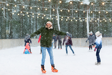 Image showing happy young man at outdoor skating rink in winter