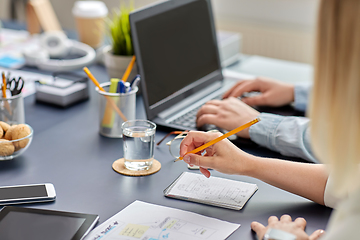 Image showing woman with notebook working on ui design at office