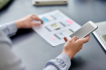 Image showing hands with phone working on ui design at office