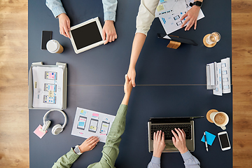 Image showing business team makes handshake at office table