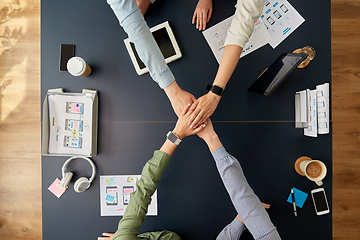 Image showing business team stacking hands at office table