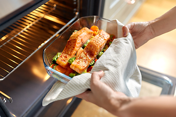 Image showing woman cooking food in oven at home kitchen