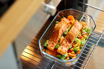 Image showing food cooking in baking dish in oven at home