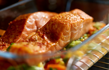 Image showing food cooking in baking dish in oven at home