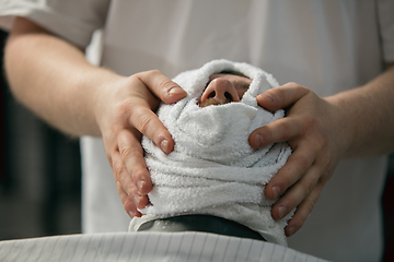 Image showing Close up of client of master barber, stylist during getting care of mustache and beard. Professional occupation, male beauty concept