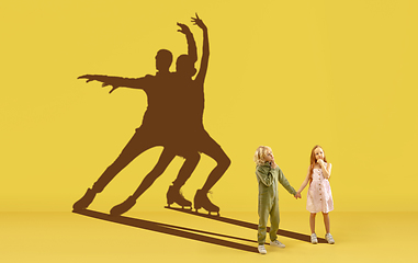 Image showing Childhood and dream about big and famous future. Conceptual image with boy and girl and shadows of fit athletes, figure skating sportsmen.