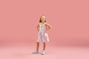 Image showing Childhood and dream about big and famous future. Pretty longhair girl isolated on coral pink background