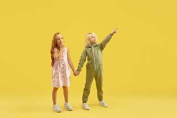 Image showing Childhood and dream about big and famous future. Boy and girl isolated on yellow studio background