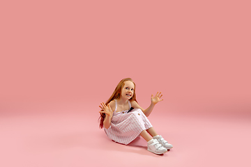 Image showing Childhood and dream about big and famous future. Pretty longhair girl isolated on coral pink background