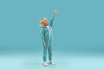 Image showing Childhood and dream about big and famous future. Pretty curly boy isolated on blue background