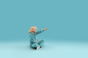 Image showing Childhood and dream about big and famous future. Pretty curly boy isolated on blue background