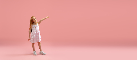 Image showing Childhood and dream about big and famous future. Pretty longhair girl isolated on coral pink background