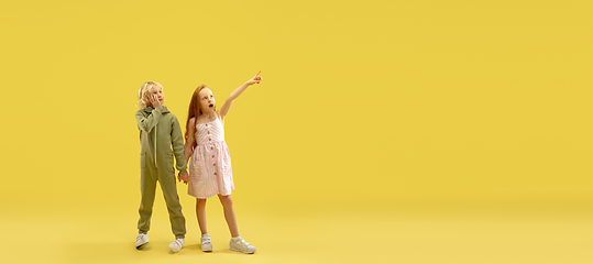 Image showing Childhood and dream about big and famous future. Boy and girl isolated on yellow studio background