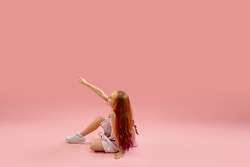 Image showing Childhood and dream about big and famous future. Pretty longhair girl isolated on coral pink background