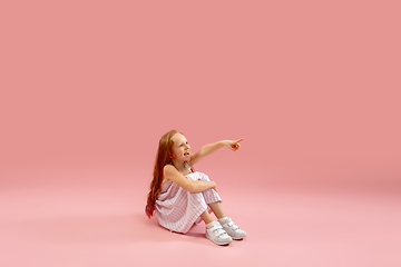 Image showing Childhood and dream about big and famous future. Pretty longhair girl isolated on coral pink background