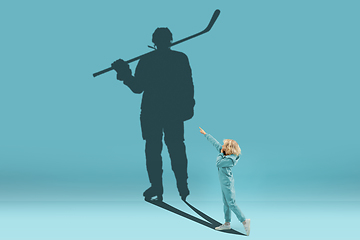 Image showing Childhood and dream about big and famous future. Conceptual image with boy and shadow of fit male hockey player on blue background