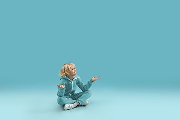 Image showing Childhood and dream about big and famous future. Pretty curly boy isolated on blue background