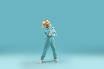 Image showing Childhood and dream about big and famous future. Pretty curly boy isolated on blue background