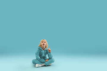 Image showing Childhood and dream about big and famous future. Pretty curly boy isolated on blue background