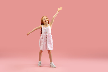 Image showing Childhood and dream about big and famous future. Pretty longhair girl isolated on coral pink background