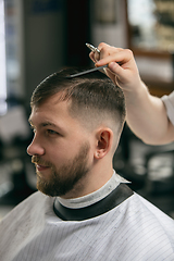 Image showing Close up of client of master barber, stylist during getting care of hairstyle. Professional occupation, male beauty concept