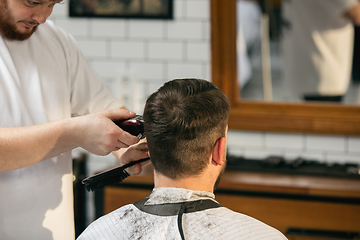 Image showing Close up master barber, stylist does the hairstyle to guy, young man. Professional occupation, male beauty concept