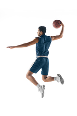 Image showing Young arabian basketball player of team in action, motion isolated on white background. Concept of sport, movement, energy and dynamic.