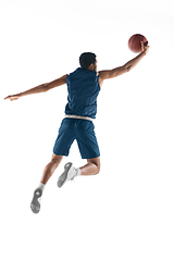 Image showing Young arabian basketball player of team in action, motion isolated on white background. Concept of sport, movement, energy and dynamic.