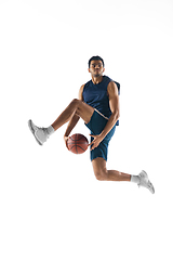 Image showing Young arabian basketball player of team in action, motion isolated on white background. Concept of sport, movement, energy and dynamic.