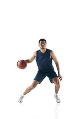 Image showing Young arabian basketball player of team in action, motion isolated on white background. Concept of sport, movement, energy and dynamic.