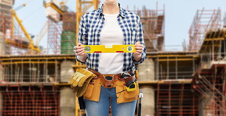 Image showing woman builder with level and working tools on belt