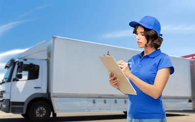 Image showing delivery girl with clipboard and pen writing