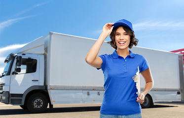 Image showing happy delivery girl with clipboard and pen writing