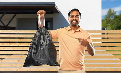 Image showing smiling indian man holding trash bag