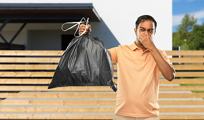 Image showing indian man holding stinky trash bag