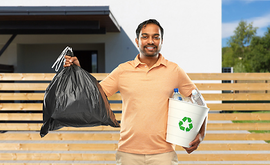 Image showing smiling indian man sorting paper and plastic waste