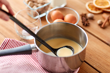 Image showing pot with eggnog, ingredients and spices on table