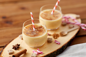 Image showing glasses of eggnog, ingredients and spices on wood