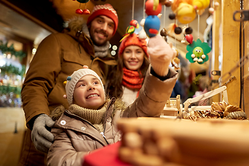 Image showing happy family buying souvenirs at christmas market